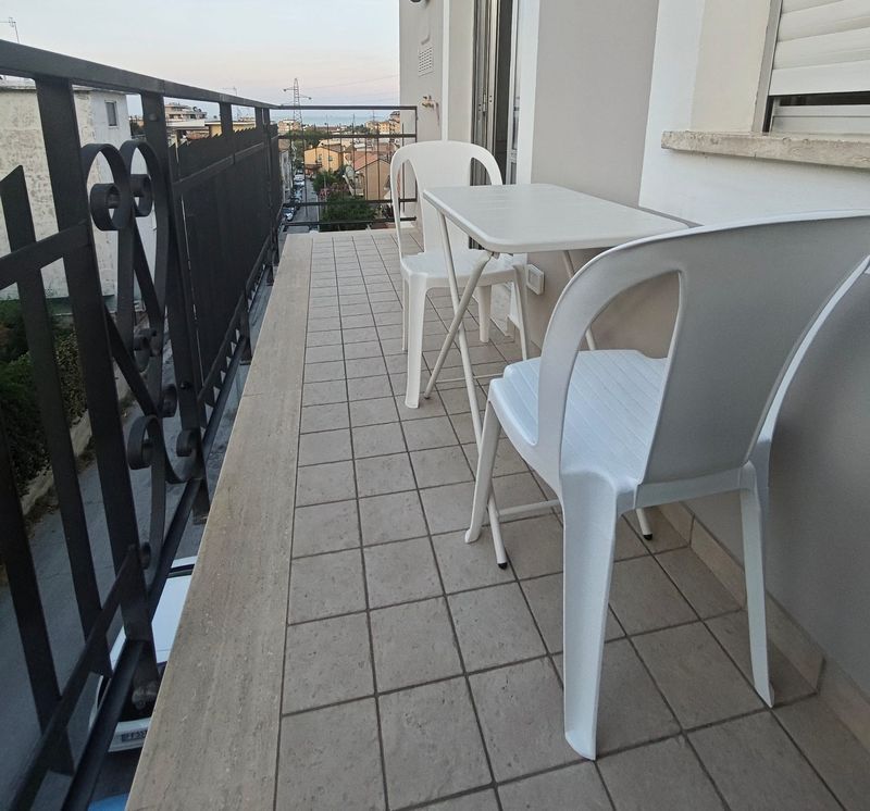 Balkon mit Stühlen und Blick über die Dächer zum Meer