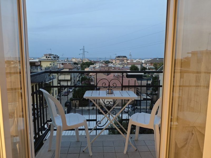 Balkon mit Tisch und Stühlen und Meerblick